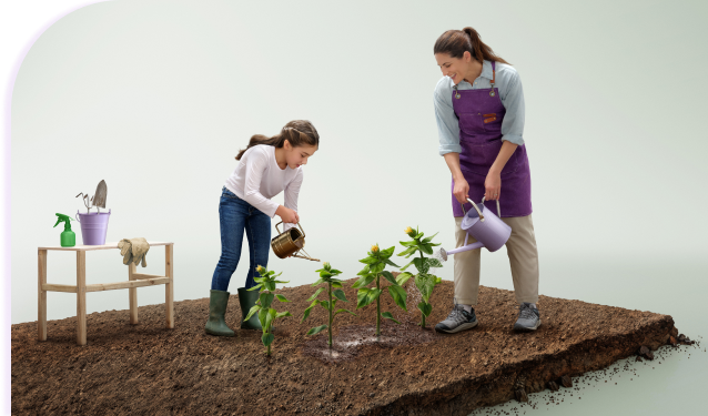 Woman wearing a purple apron and a child watering plants, with a table containing gardening tools besides them