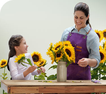 Mom and daughter placing sunflowers in vases