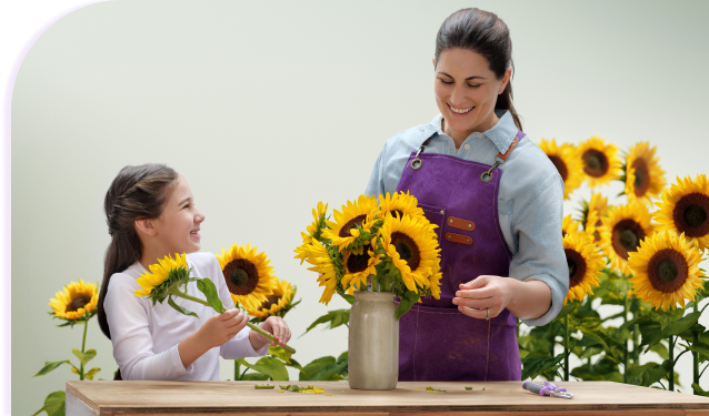 Mom and daughter placing sunflowers in vases