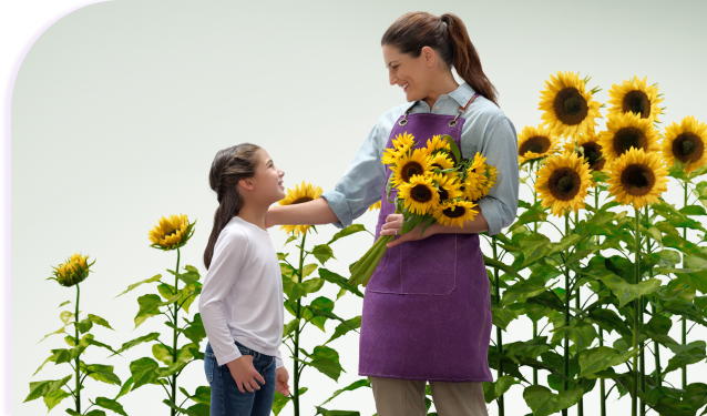 A woman holding a bouquet of flowers, smiling warmly at the child standing beside her