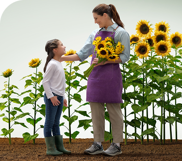 A woman holding a bouquet of flowers, smiling warmly at the child standing beside her