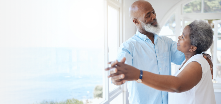 Senior couple dancing seaside