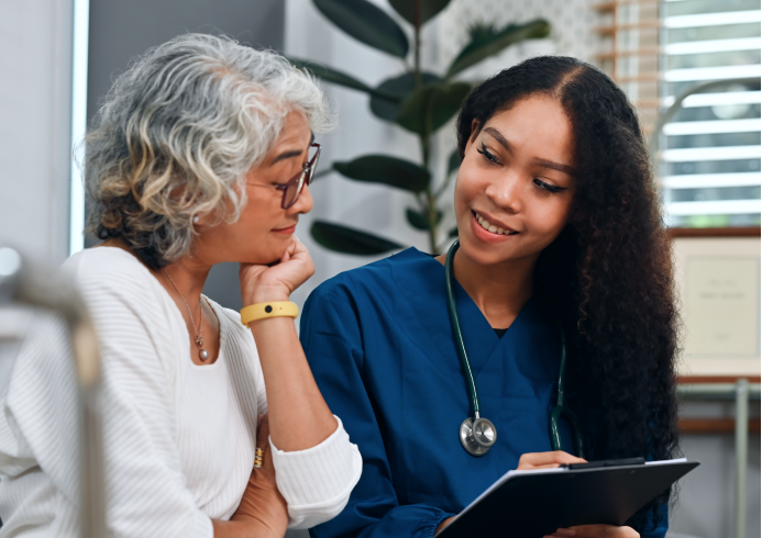 A young female healthcare professional consulting a senior woman
