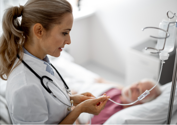 A female doctor with a stethoscope adjusts an IV drip