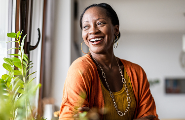 A cheerful woman sits by a window