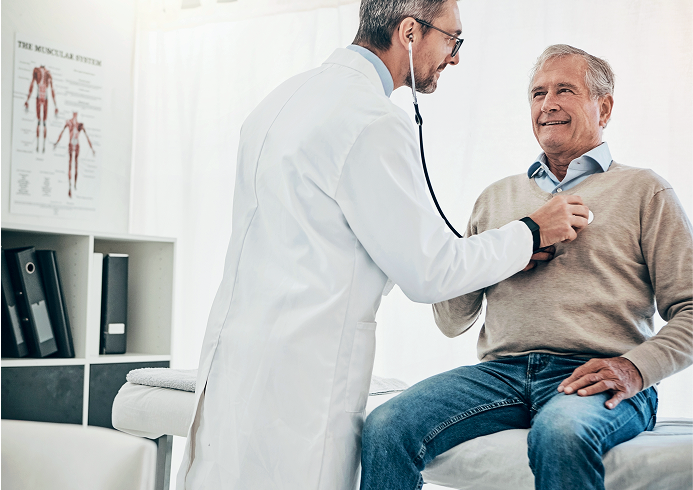 A male doctor uses a stethoscope to check the heartbeat of a senior male patient 